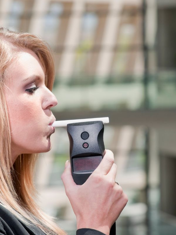 A woman taking a breathalyzer after being pulled over for a DUI in Columbus