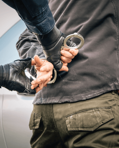 cuffs a man being handcuffed against a car by police in Columbus