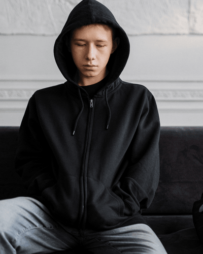 juvenile-charge a young teen in a hooded sweatshirt looking sad while facing juvenile charges