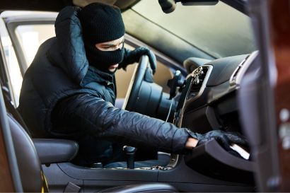 theft a man in a mask stealing from a car