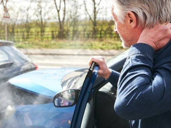 a man holding his neck after a car accident